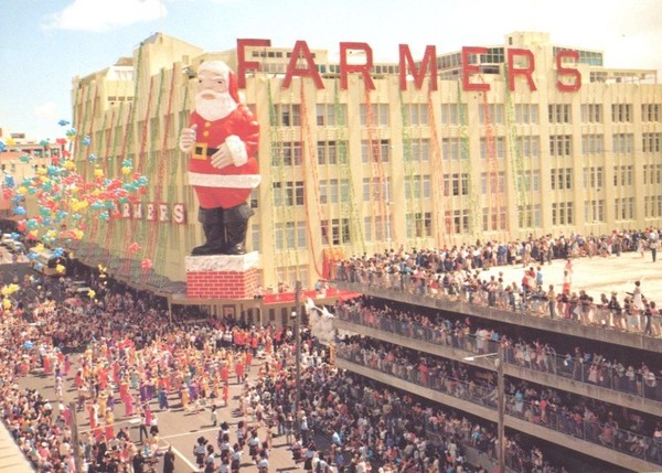 Thousands watch the 1983 Farmers Santa Parade pass the 79 foot giant Santa outside the Hobson Street store